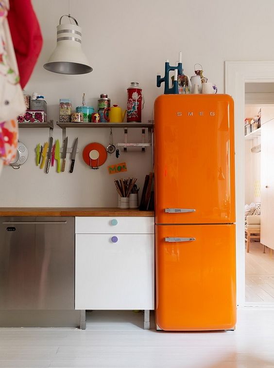 an eclectic kitchen with a bold orange Smeg fridge for a wow factor