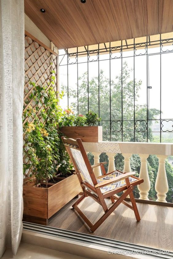 a balcony with folding furniture, potted plants and blooms is a cool and lovely space to have a rest