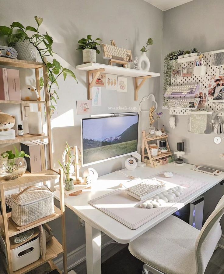 a beautiful white workspace with a desk and a chair, a shelving unit with decor and books, devices and decor on the shelves, a pegboard with things stored