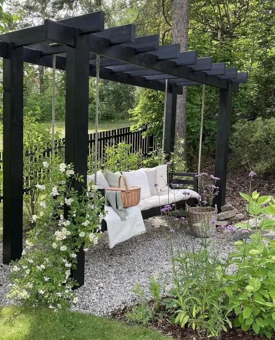 a black arch with a bench, with pillows and blankets, some flowers and greenery around is pretty and cool for a Scandinavian garden