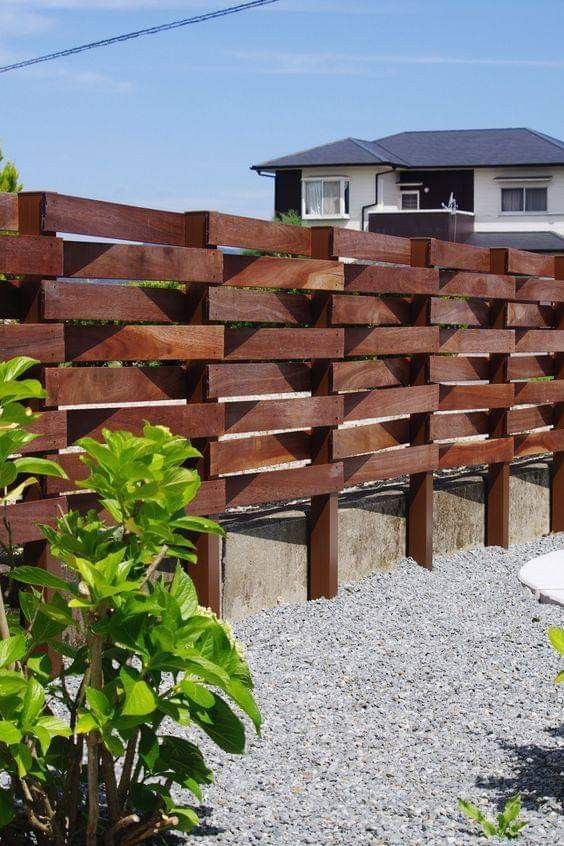 a bold and catchy rich-stained wooden fence with a pattern is a creative solution for a modern backyard