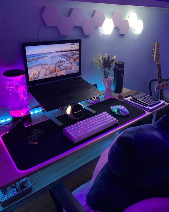 a bold space with a laptop on a stand, some cool devices, a unique lamp and a hex wall lamp is amazing