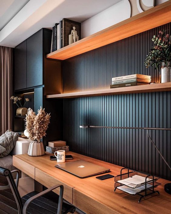 a chic black modern workspace with a planked wall, shelves with decor and lights, a desk with pampas grass and a table lamp