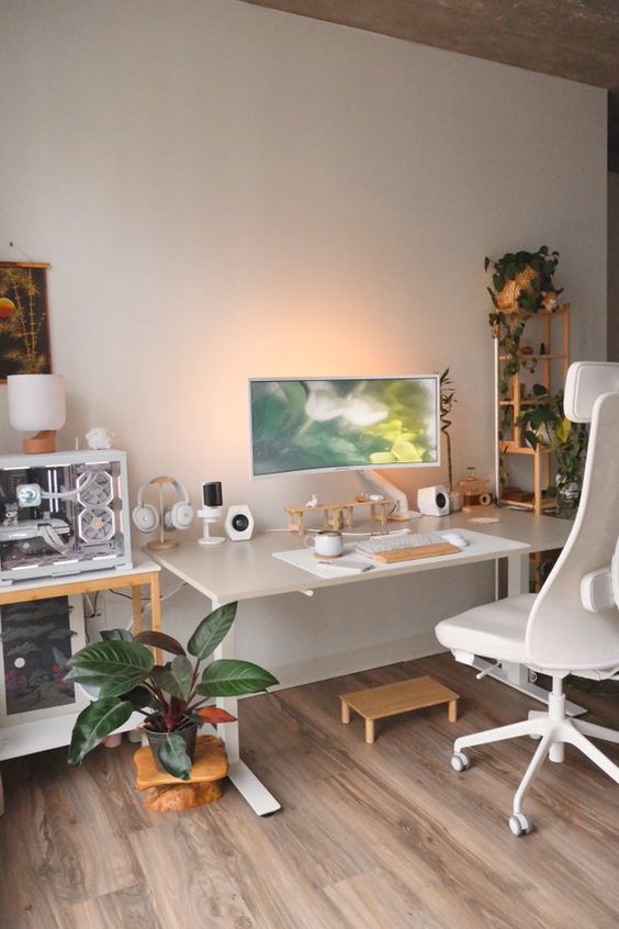 a chic workspace with a white desk and chair, a PC, devices, potted plants and lamps