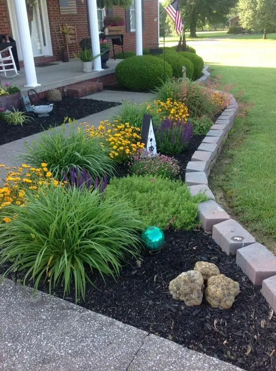 Brick edging is perfect to create a small curved area with blooms and rocks. It adds interest to the front yard with shape and color.