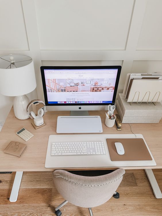 a clean and minimal workspace with a desk and a chair, some devices, a table lamp and some papers is pure elegance