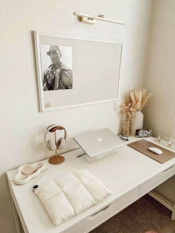 a clean minimal workspace with a white desk, some dried herbs, some dives and a memo board with a photo