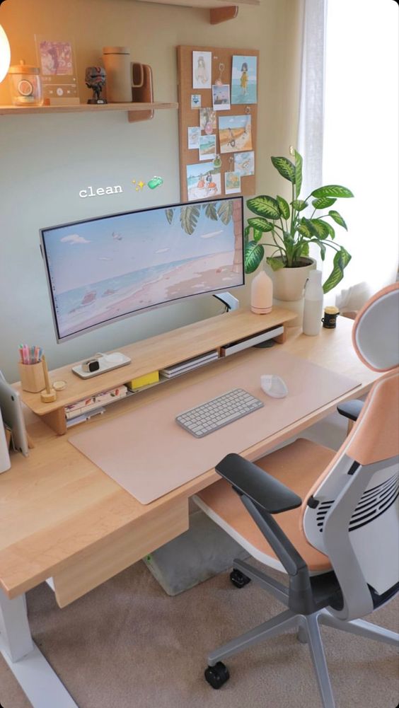 a clean workspace with a desk and a stand with a monitor, greenery, a cork board with photos, a shelf with decor and a comfy chair