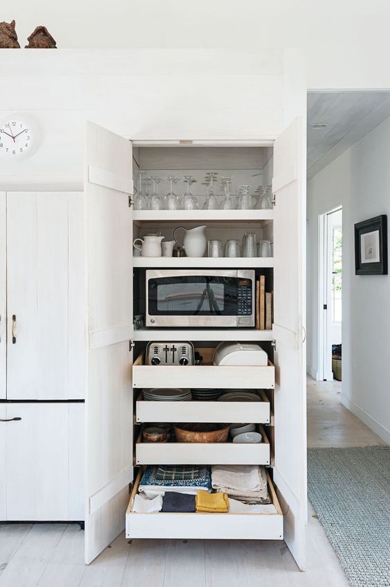 a functional cabinet with shelves and mini drawers holding glasses, mugs, cups and some appliances is a very smart idea