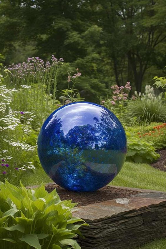 a glossy blue sphere is a colorful accent for a modern garden, it will stand out and will become a unique decor feature