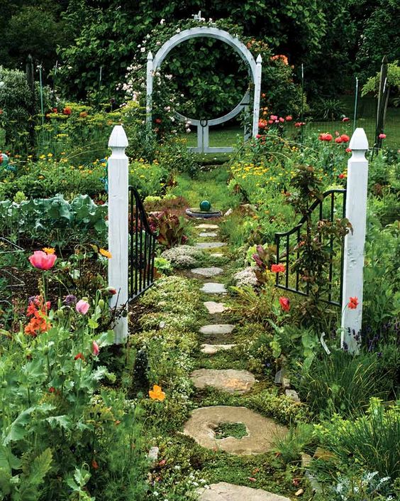 a gorgeous fairy-tale space with greenery, lots of bright blooms and a vintage gate just as a decoration