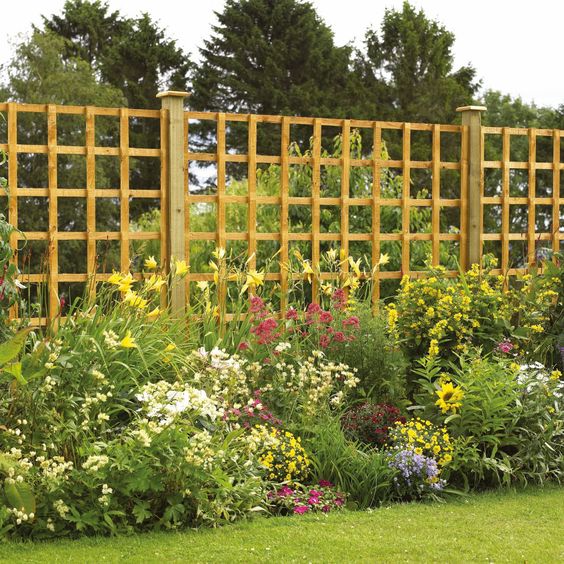 a light-colored grid fence surrounded with colorful blooms looks lightweight and airy and continues the landscape style
