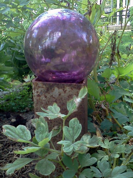 a lilac glass ball on a metal stand will add color to your greenery, a great idea for a shady garden where flowers can't grow