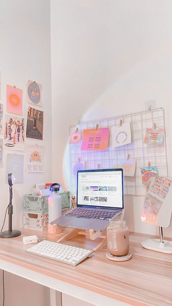 a little workspace in the corner, with a laptop on a stand, a grid with memos, a gallery wall and some lovely decor