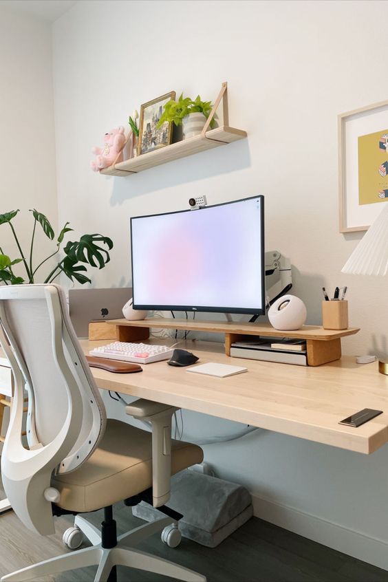 a minimal and clean workspace with a desk, a neutral chair, potted plants, a shelf with decor and a PC plus some devices