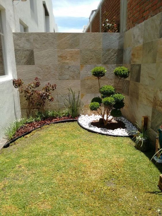 a minimal space with a green lawn, a corner garden with topiaries and pebbles is a cute little nook with a fresh touch