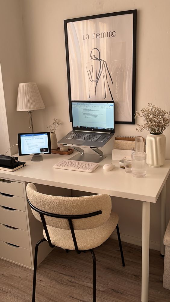 a minimal workspace with a white desk and chair, blooms in a vase, devices and an artwork is amazing