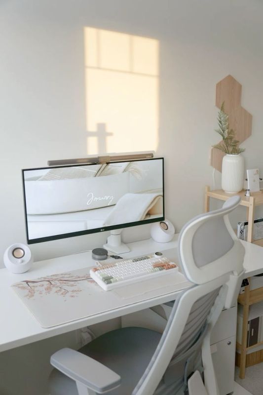 a minimal workspace with a white desk and chair, devices and some decor on the shelf is a cool space to work