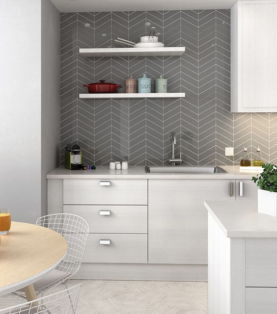 a modern neutral kitchen with a grey chevron tile backsplash, open shelves, built-in lights and greenery