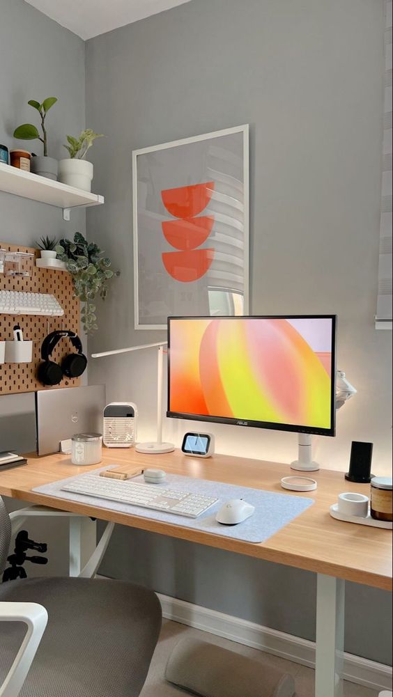 a pretty and aesthetic workspace with a pegboard holding various stuff, a shelf with potted plants, a PC and some more devices