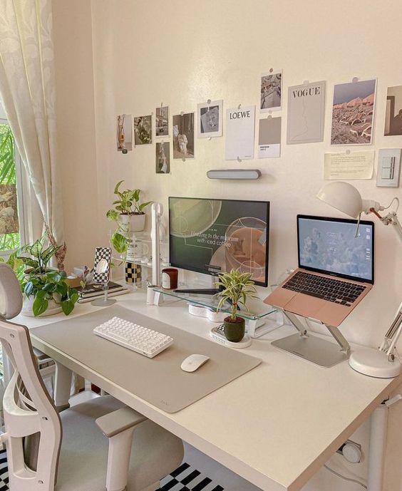 a pretty workspace with a PC and a laptop, a gallery wall, potted plants and a table lamp is amazing