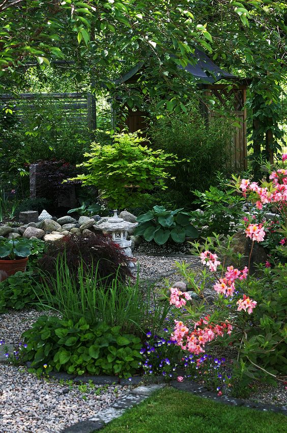 a shady nook with greenery, trees and bold blooms, a stone lantern, some pebbles and rocks is amazing for your non-sunny plot