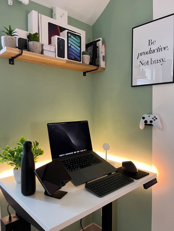 a small and pretty workspace with a lamptop and some other devices, a potted plant and a shelf with everything necessary over the desk