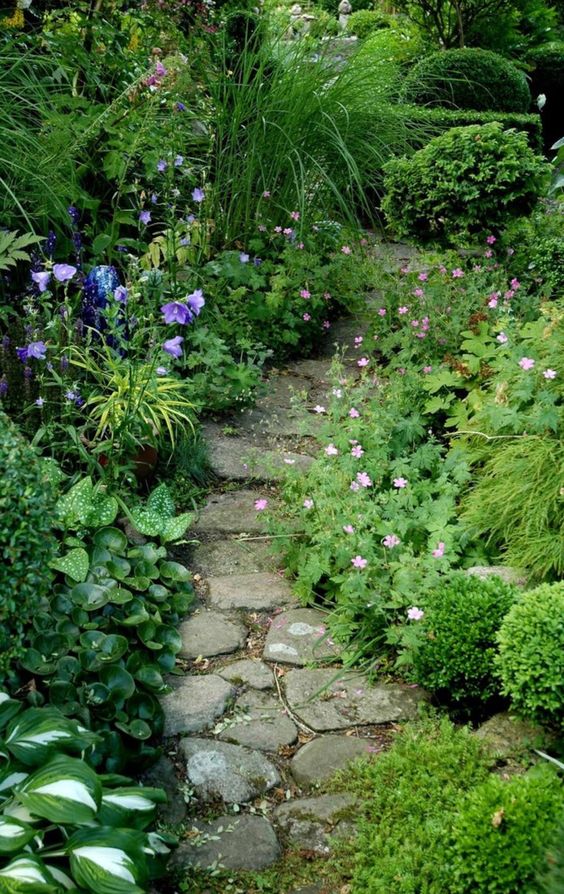a small and shady spot with greenery, shrubs, bright blooms, a rock path is a stunning idea for any garden