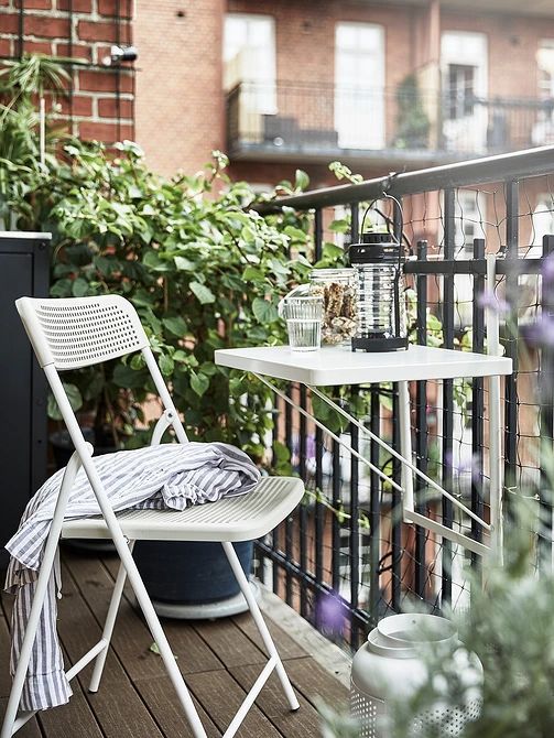 a small white metal folding table attached to the balustrade is a lovely solution to save floor space and serve whatever you want