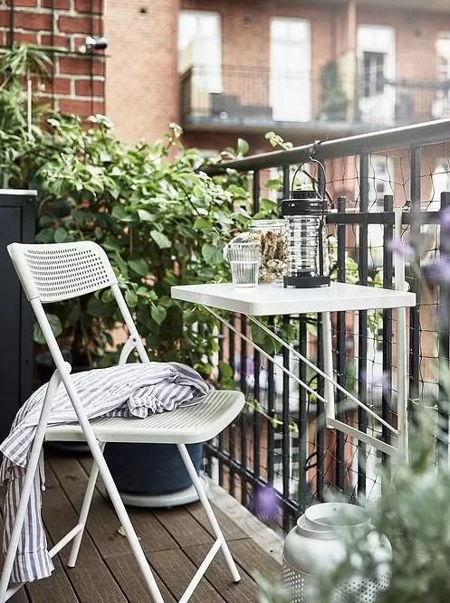 a small white metal folding table attached to the balustrade is a lovely solution to save floor space and serve whatever you want