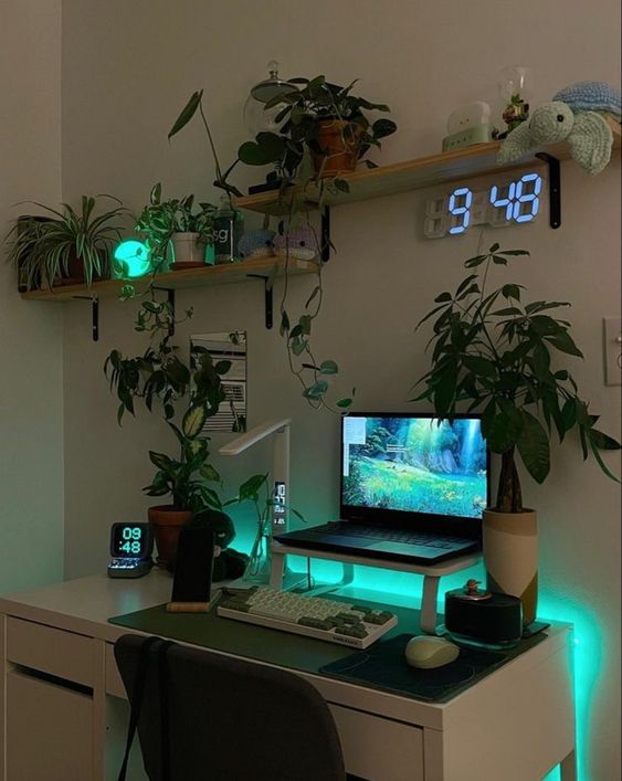 a small yet cool space with a laptop on a stand, potted plants, lights, a clock and some devices and decor on the shelves