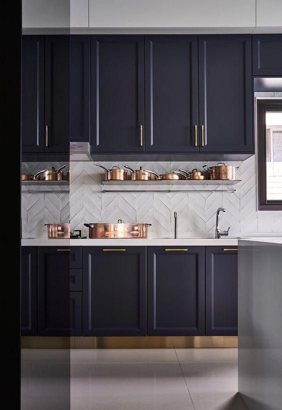 a sophisticated midnight blue kitchen with textural white chevron tile backsplash and some copper touches for more elegance