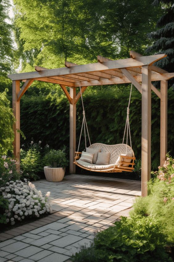 a stained arbor frame with a hanging curved loveseat and pillows is a lovely nook to spend some time and enjoy coziness