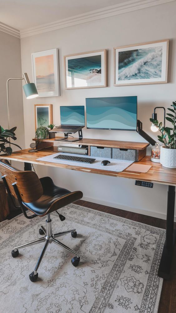 a stylish workspace with a large desk, with storage drawers, a PC and a lamptop, a gallery wall and a chic chair