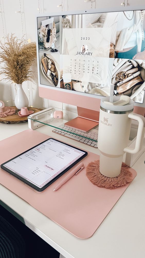 a tiny and cute workspace with a desk, pink accessories, a PC, a tree coaster, grasses and a woven placemat is amazing