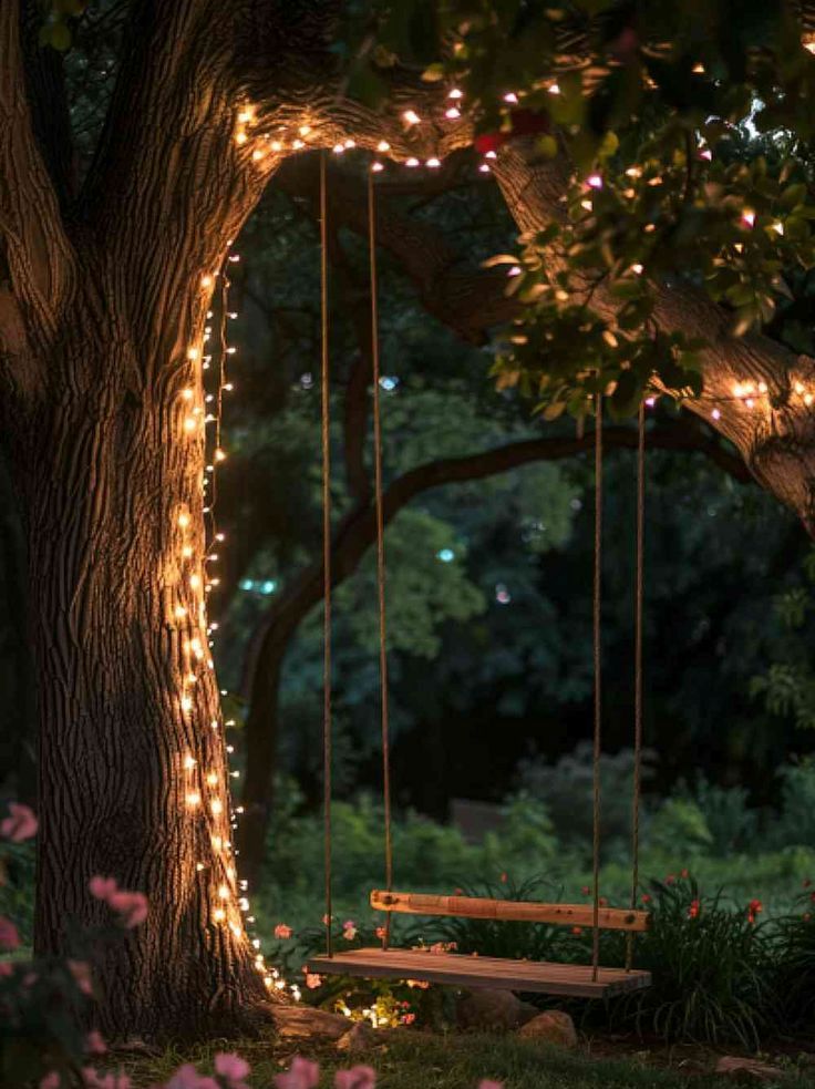 a tree decorated with lights and surrounded with blooms, plus a swing create a magical feel in the garden