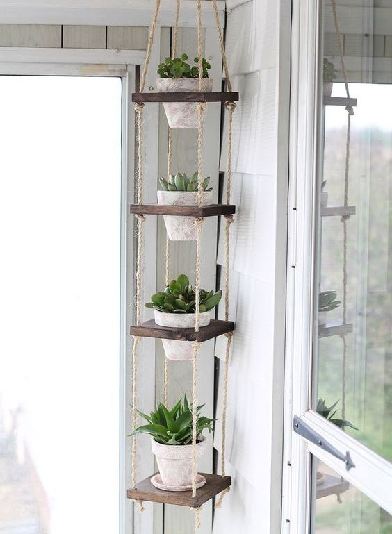 a vertical plant hanger of stained wood, twine and whitewashed planters is a lovely idea not only for a balcony but also for any other room