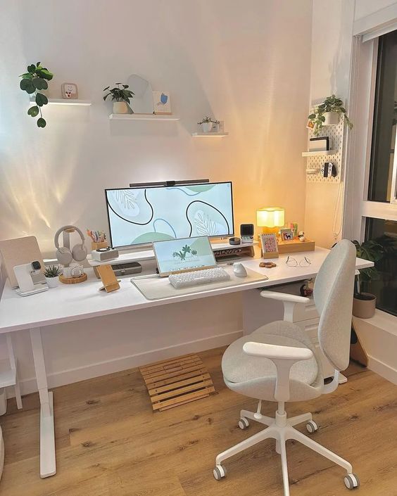 a white aesthetic workspace with a desk and a chair, potted plants, some decor and devices is amazing