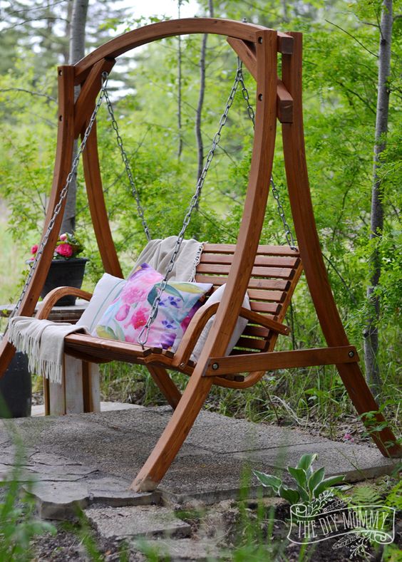an arched frame with a swing chair and pillows is a great idea if you want a spot to have a rest