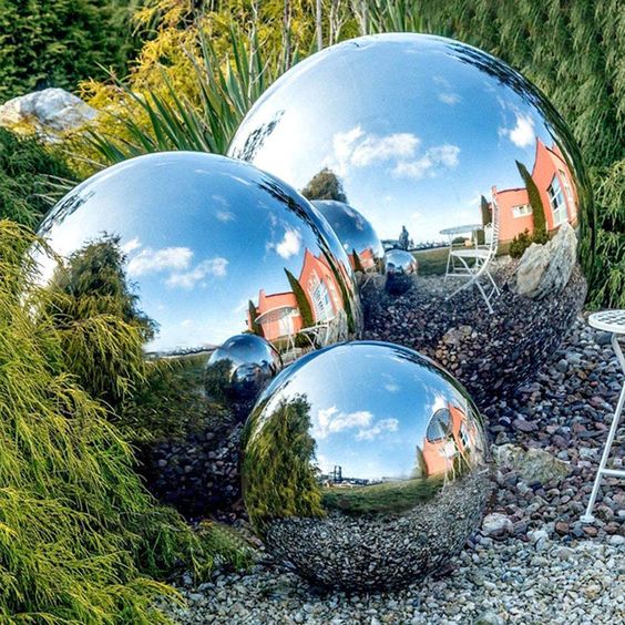 an arrangement of mirror garden balls on the ground will make your space unique, bold and modern