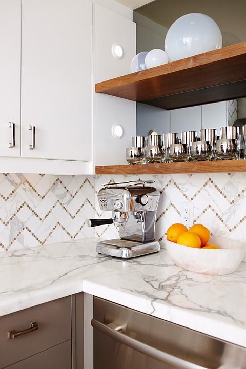 an elegant stained kitchen with open shelves, a cool chevron tile backsplasj and white countertops is wow