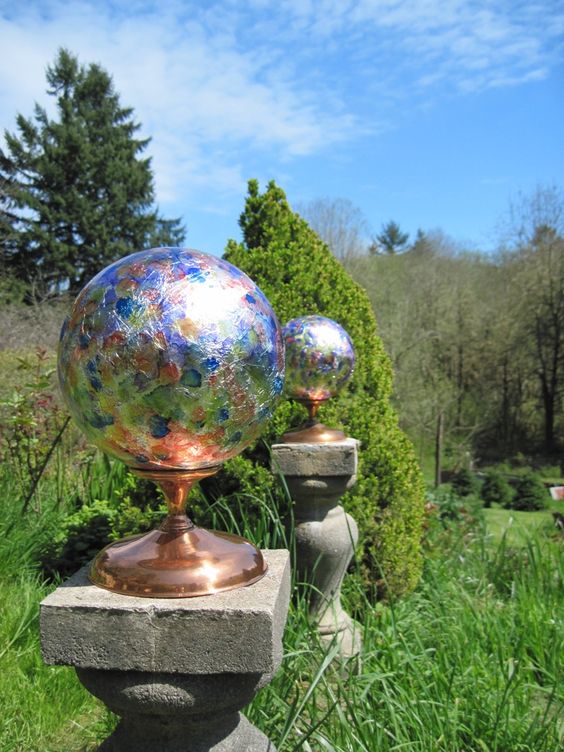 colorful glass balls on copper stands are amazing to accent a green garden, they bring timeless elegance and a bold touch