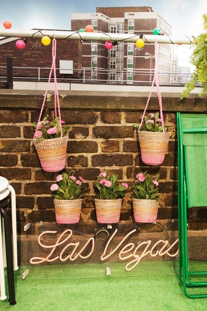 a colorful light garland, bright plant holders hanging on the railing for pretty balcony decor without using any floor space