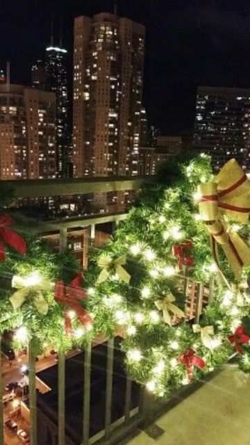 a greenery garland and wreathwith lights and red and gold bows to decorate the balcony for holidays