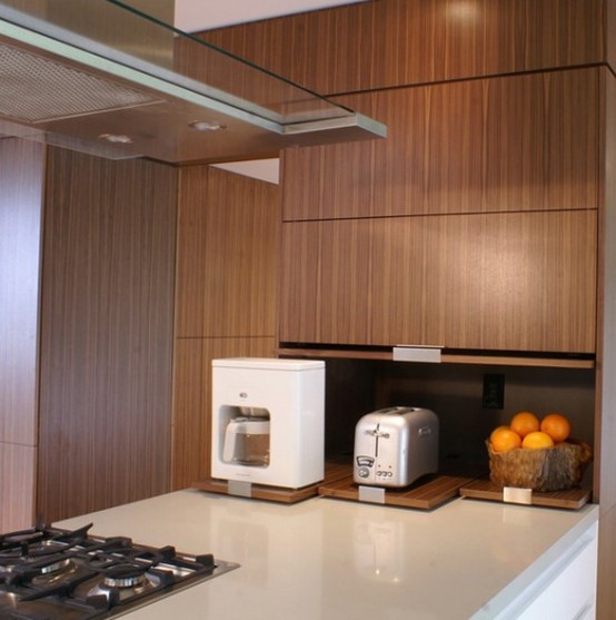 a sleek cabinet with retracting shelves and appliances and fruits in a bowl for a minimalist kitchen