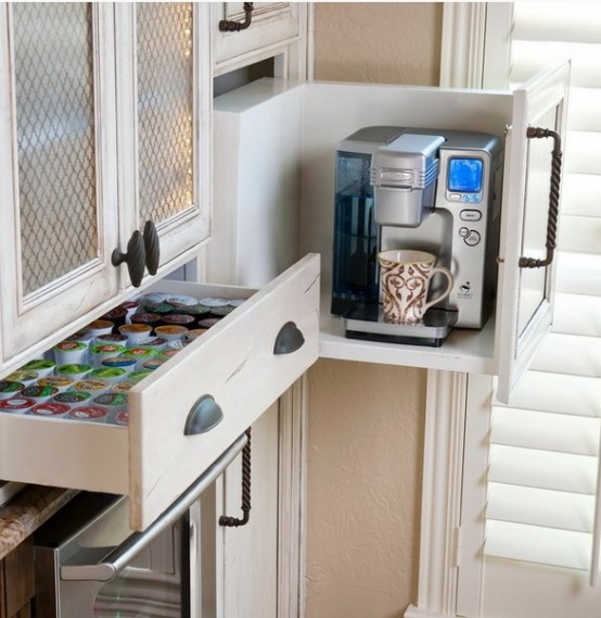 a large drawer with a removed part holds a coffee machine and a drawer next to it holds everything you may need for a coffee