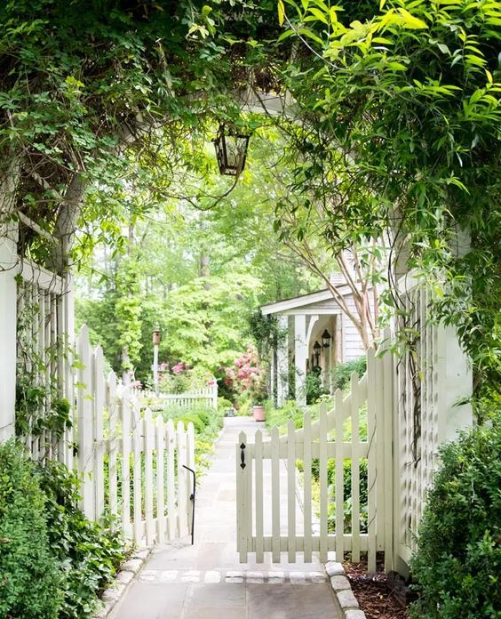 greenery at and over the gate make the entrance feel natural, and a bit secret garden-like, even though there are no blooms