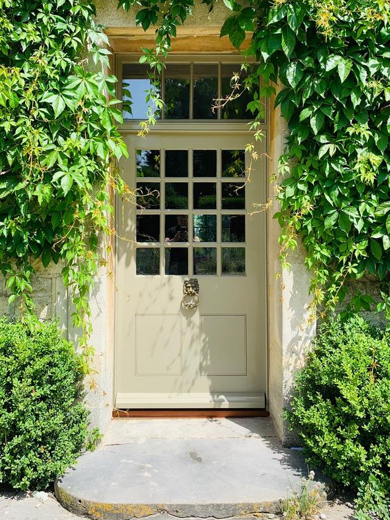 Make a very neutral and simple entrance bolder with lush green vines going over the door and matching greenery planted. 