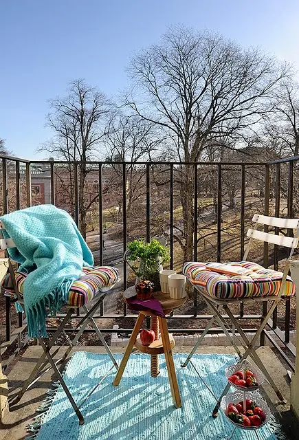 We all need some colors in early Spring so a bright blanket, a colorful rug and stripped floor pillows would be a great addition to a balcony's decor