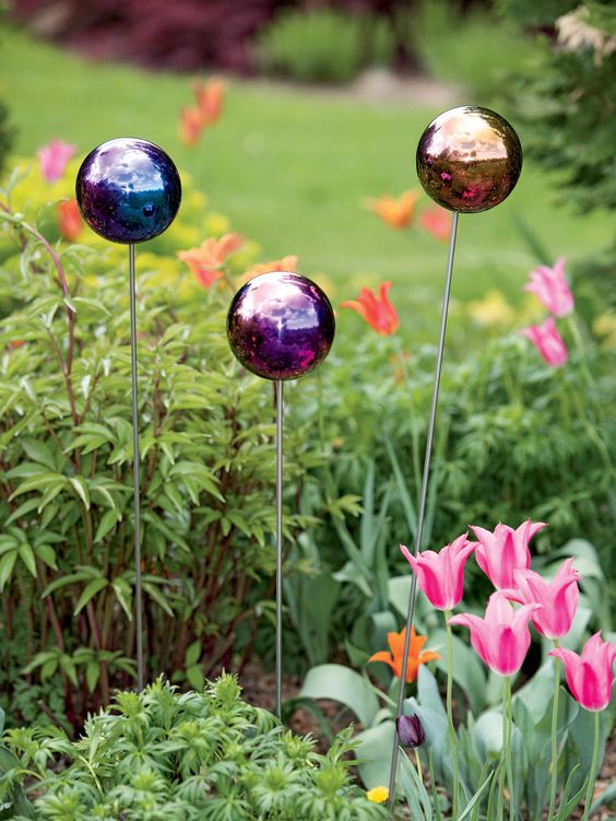 small colorful glass balls on metal stands can accent your flower bed adding more color and interest to the space